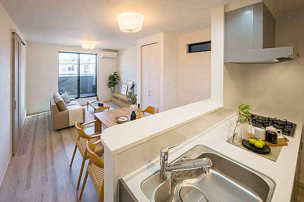 【【LDK】】キッチンの前面には腰壁を設けているので、調理中の手元を隠すことができます。階段部分には扉があり、居住部分のプライバシーを守れる間取り設計です。