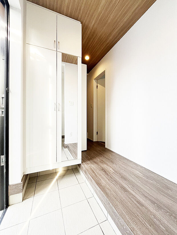 【すっきり片付く玄関～5号棟】散らかりがちな玄関をスッキリと保てる玄関収納は、家の中に入る時一番最初に目に付く場所だからこだわりたい。落ち着いた雰囲気の色目が、室内のカラーやデザインと調和しています。
