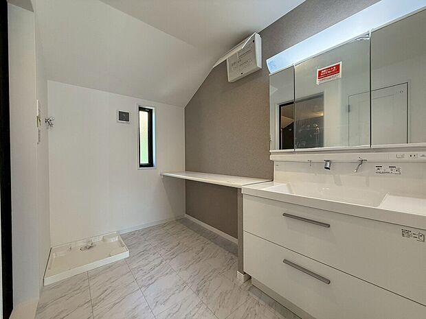 【洗面室・洗面台】鏡の裏に収納棚を確保した三面鏡を採用。化粧品や歯ブラシなどを機能的に収納。また、三面鏡の本当の利点は三枚の鏡を合わせることで、頭の側面や背面が見れること。
