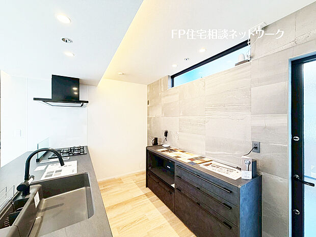 【機能性と美しさを兼ね備えたシステムキッチン】ダークグレーで統一されたシステムキッチンは、空間に深みと洗練をもたらす上質なデザイン。機能性に優れたカップボードも備え、スタイリッシュさと使いやすさを兼ね備えたキッチンです。