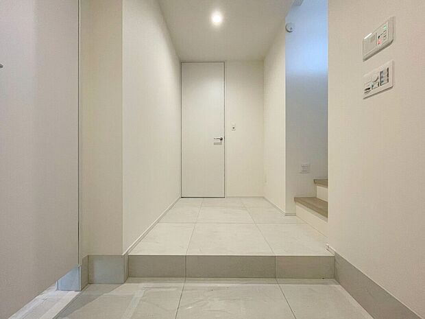 【玄関(２号棟)】クリーム色の壁紙が、暖かい雰囲気を演出する玄関