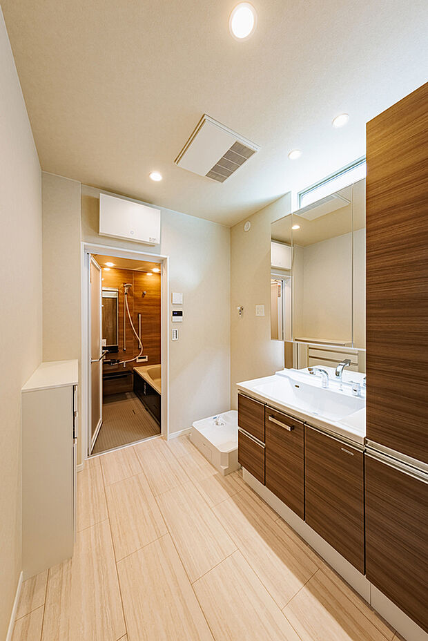 【洗面脱衣室】T-1/洗う・干す・しまうが、ひとつの流れで完結。2階に洗面脱衣室を配置した洗濯動線が、毎日の洗濯を心地よくスマートに。サイドキャビネット付きの洗面化粧台には、タオルや洗剤のストックもすっきり収納。