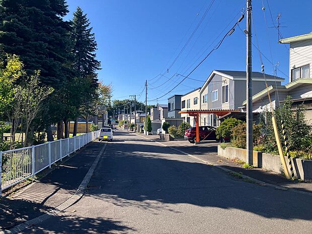 【現地写真】
緑豊かな公園が近く、四季の移ろいを感じられるロケーション。前面道路は車通りも少なく静かな環境も魅力です。
(2025年10月撮影）