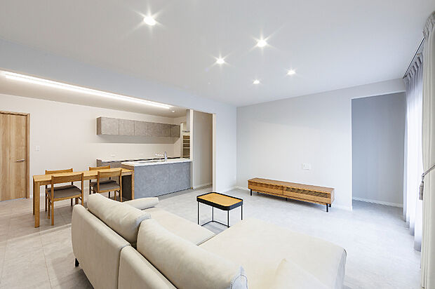 【【リビング／モデル(1)】】約21帖のLDKは、家具を置いても家族でゆったり過ごせる快適な空間。グレーを基調とした内装にナチュラルな木目を合わせ、落ち着いた上質な雰囲気です。
（2025年11月撮影）