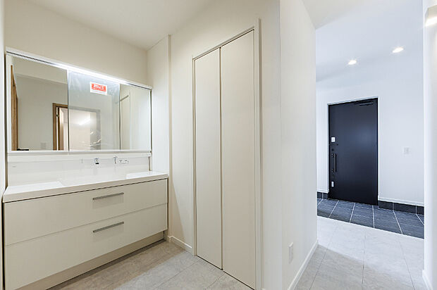 【【洗面室／モデル(1)】】幅120cmのワイド洗面台は家族で並んで使えるゆとりの広さ。収納も充実し、タオルや小物もすっきり片付く設計。玄関直結の動線で帰宅後すぐに手洗いできます。
（2025年11月撮影）