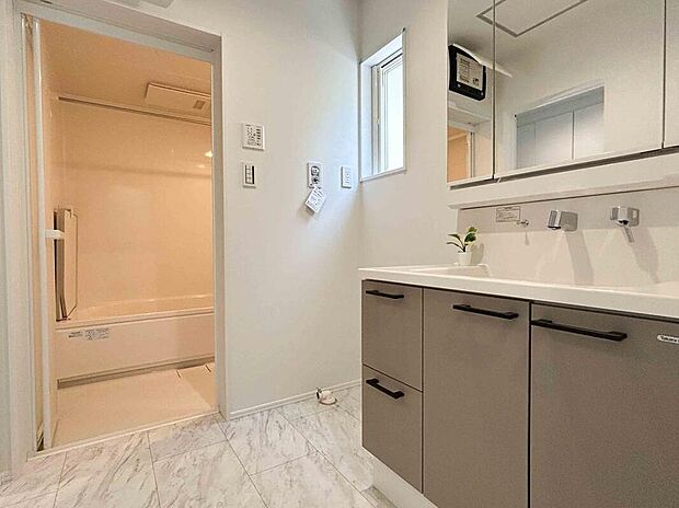 【【洗面脱衣室】】洗面台の収納は、小物類をしまう際に便利な引き出しと扉の組み合わせです。ミラー裏にも収納スペースが備わっており、散らかりがちな洗面脱衣スペースをすっきりと保てます。/2025年4月撮影