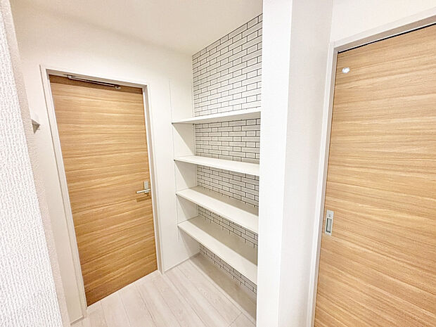 【【パントリー兼ファミリークローゼット ｜ 1号棟】】玄関から、パントリー兼ファミリークローゼットを経てキッチンにつながる動線