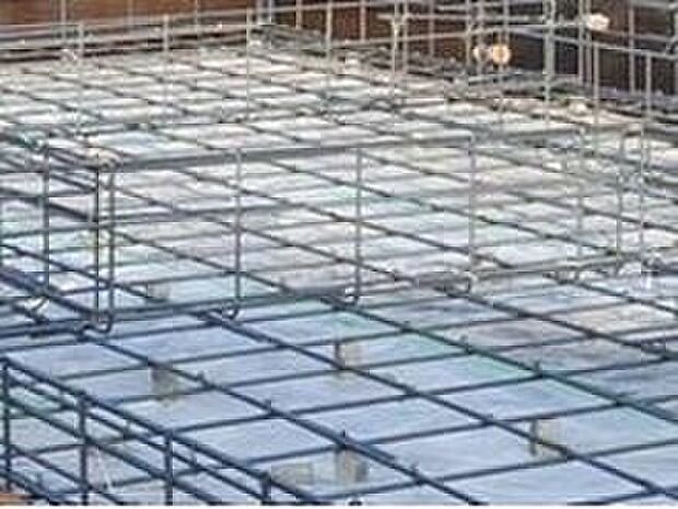 【足元を支えるベタ基礎】立ち上がりと底面全体が一体の鉄筋コンクリート造（仕上がり幅150ｍｍ・底盤厚150ｍｍ）。　「不同沈下」や「地面からの湿気」に対する有効な措置と言えます。　また、基礎と土台とをつなぐアンカーボルトは、大きな地震などにより建物が基礎から外れたり持ち上げられたりしないための役割があります。