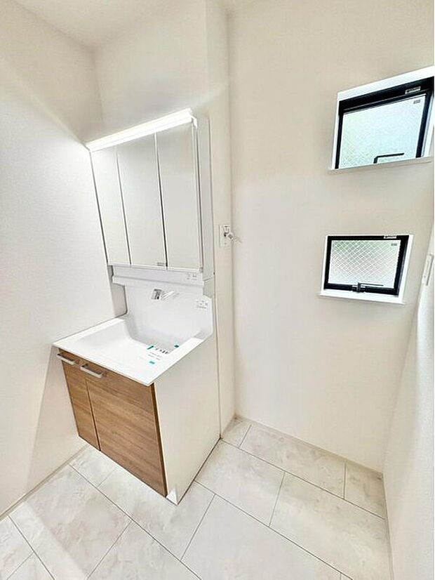 【洗面所】三面鏡ならではの収納力、温水シャワー付きの機能性、どちらも採用！汚れが落ち易い大型の洗面ボウルは手入れもしやすく日々の生活を陰ながら支えてくれる仕様となっております。