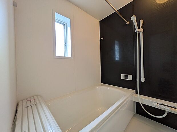 【浴室】1号棟写真　浴槽は無駄をなくした節水タイプで、浴槽内ステップで半身浴や親子入浴もゆったり楽しめます。温めたお湯が冷めにくい保温タイプの浴槽で入浴時のお湯のぽかぽかが持続します。また、乾きやすい床面はお掃除がしやすく、カビの発生を抑制します