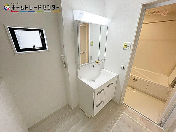 【洗面台・洗面所】２号棟
散らかりがちな洗面所も三面鏡うしろの収納でスッキリ！サニタリースペースには窓が備えられております。毎朝の身支度も、陽の光差し込む明るい空間で、快適にお使い頂けそうです。