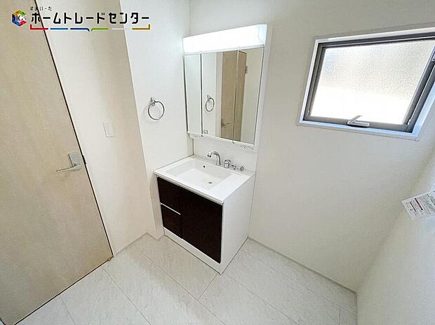 【洗面台・洗面所】３号棟
女性にはうれしい３面鏡化粧台。鏡の裏が収納になっている機能的なタイプです。窓が備えられております。毎朝の身支度も、陽の光差し込む明るい空間で、快適にお使い頂けそうです。