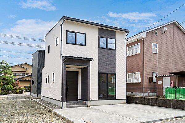 ベージュの外壁をベースに、中央のダークカラーがアクセントになったモダンな外観。シンプルで飽きのこないデザインが、街並みにも自然に調和する住まいです。