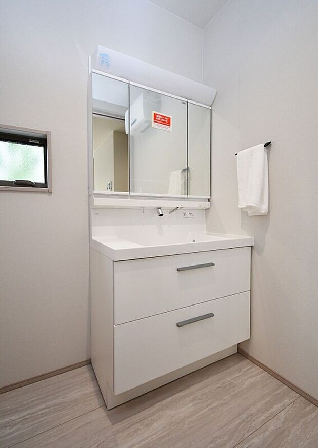 【(2)号棟　洗面】ホテルライクな洗面台は三面鏡裏に大容量の収納付き。すっきりとした印象が続く空間設計。※施工事例です。実物とは異なります。