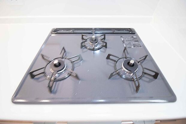 【ガスレンジ】三口コンロで料理の幅を拡げてくれる使いやすいシステムキッチンを採用。洗い場も大きいので野菜や食器を洗ったりする際にも捗り、奥様の強い味方となってくれるはずです。