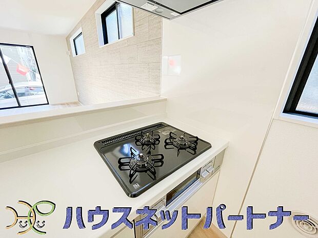 【キッチン】三口コンロで料理の幅を拡げてくれる使いやすいシステムキッチンを採用。洗い場も大きいので野菜や食器を洗ったりする際にも捗り、奥様の強い味方となってくれるはずです。