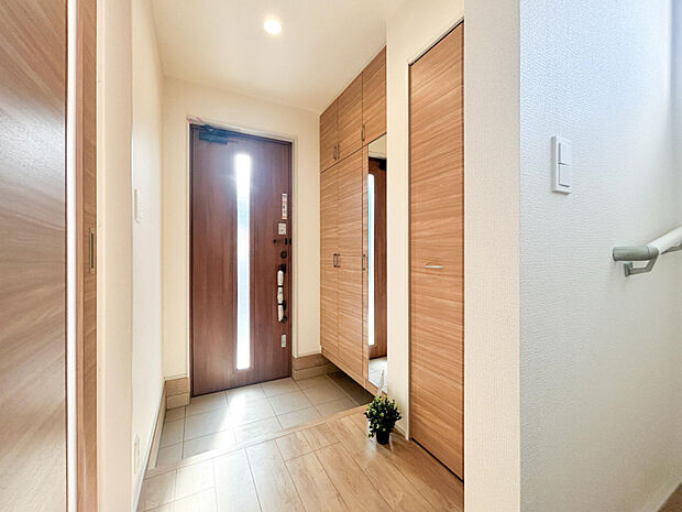 【8号棟/玄関・玄関収納】　木目調の色合いが魅力の玄関収納です。約32足～52足の靴が収納可能＋ミラー付きの玄関収納でお出かけ前の身だしなみチェックが出来ます。