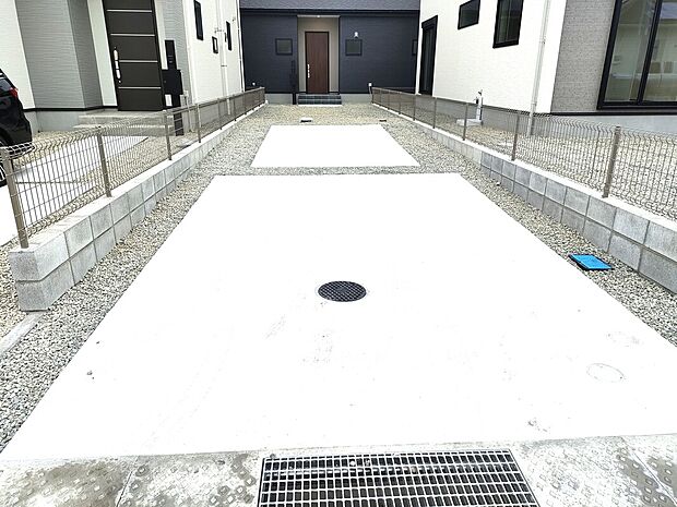 【2号棟駐車スペース】縦列で3台駐車可能なスペースは、車種を選ばず使いやすい設計。コンクリートと砂利を組み合わせた舗装で清潔感もあり、外構も整えられた防犯性に配慮された快適な駐車場です♪