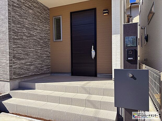 【A号棟玄関】『家の顔』とも言える玄関は、明るく暖かみのあるな印象。ベージュのタイルが美しく機能的なアプローチはご家族や来訪者を優しく迎え入れます。