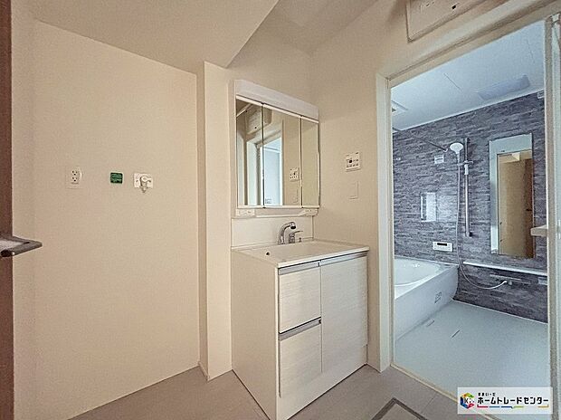 【2号棟洗面脱衣室】白を基調とした清潔感あふれるパウダールームは機能性とデザイン性を両立させた快適空間。毎日の身支度や入浴時にも気持ちよくお使いいただけます。