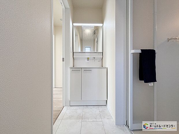 【G号棟洗面化粧台】白を基調とした清潔感あふれるパウダールームは機能性とデザイン性を両立させた快適空間。毎日の身支度や入浴時にも気持ちよくお使いいただけます。