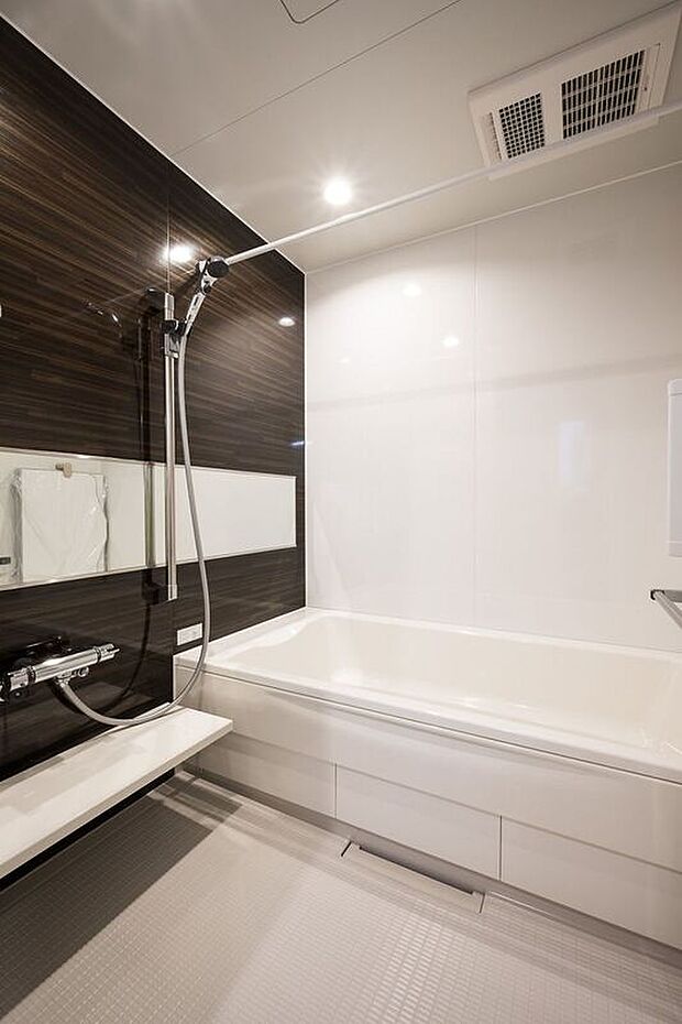 ■6号地バス　スタイリッシュなダークブラウンのアクセントパネルが印象的な浴室。ワイドミラーが空間に奥行きをもたらし、広々とした印象を与えます。浴室乾燥機完備。
