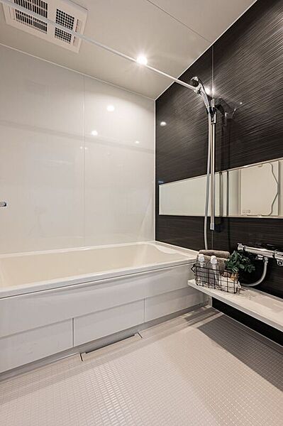 ■E号地バススタイリッシュな黒のアクセントパネルが印象的な浴室。ワイドミラーが空間に奥行きをもたらし、広々とした印象を与えます。