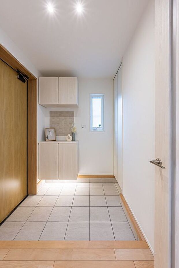 【玄関】■1号地玄関1号地の玄関です。木目を活かした明るい空間です。天井吊りの収納と間接照明が、圧迫感を与えずに機能性とデザイン性を両立しています。