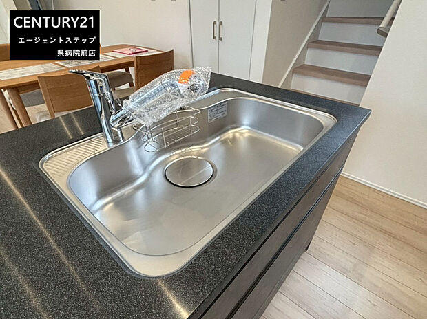 【キッチン設備】広々としたキッチンシンクが設置されており日々のお手入れがしやすい仕様です。作業スペースもゆとりがあるので調理が快適です。シンプルなデザインが空間に馴染みます。水栓も使いやすい位置に配置されています。