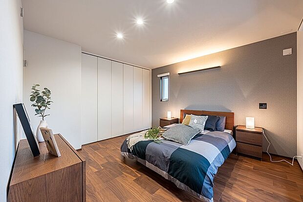 【寝室】■主寝室 落ち着いたグレーのアクセントクロスと間接照明が安らぎを演出する約10.4帖の主寝室。ベッドを並べてもゆとりがあり、収納スペースも完備して居室をすっきり保てます。