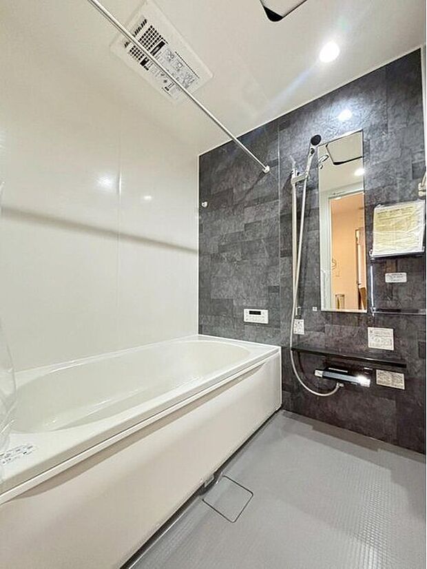 【浴室】１号棟
アクセントパネルで落ち着きのある雰囲気を演出したバスルーム♪毎日の疲れを癒やすバスタイムをお楽しみ下さい！浴室換気乾燥暖房機付きで、ジメジメした季節や雨の日には、浴室内干しも可能！