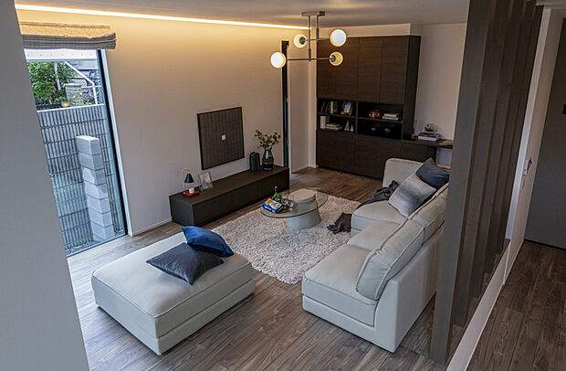 【リビング】間接照明が柔らかく広がる落ち着いたリビング空間。穏やかな色調と奥行きのある壁面デザインが、上質で心地よいくつろぎを生み出します。