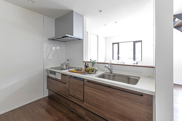 【キッチン】スタイリッシュなシステムキッチンで、お料理も毎日の家事も快適に。充実した収納スペースと最新設備が、スマートな暮らしをサポート。美しい木目調フローリングが、モダンな空間に温もりを添えます。