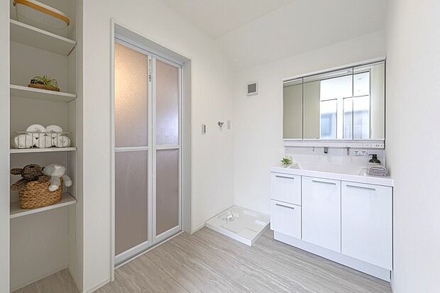 【洗面】ゆとりの洗面スペースで朝の身支度もスムーズに。鏡裏収納＆便利なオープン棚で化粧品やタオルもスッキリ整理整頓。洗濯機置場も隣接しており、家事効率アップ！毎日を快適に過ごせる工夫が凝縮された空間です。