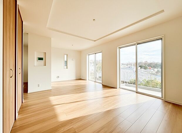 【リビング】明るい光が差し込む大きな掃き出し窓が、18帖以上の広々としたLDKに圧倒的な開放感をもたらします 。高台ならではの抜けた眺望を室内から贅沢に楽しめ、家族が集う場所を一層心地よい空間へ。