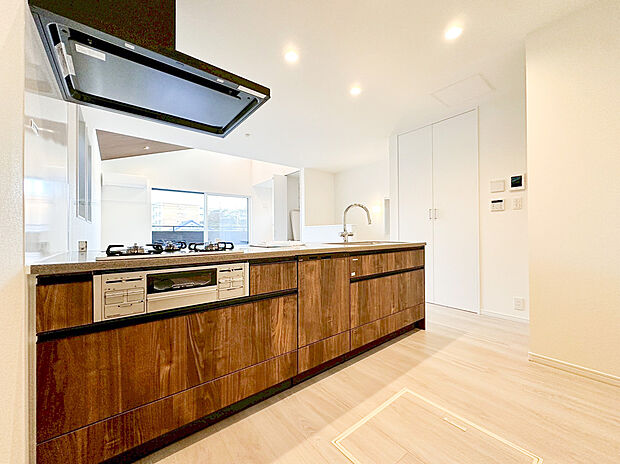 【キッチン】複数の窓から自然光が入り、明るく清潔感あふれる空間で、気持ちよく調理ができます。カウンターには3口ガスコンロが搭載され、換気扇も強力。