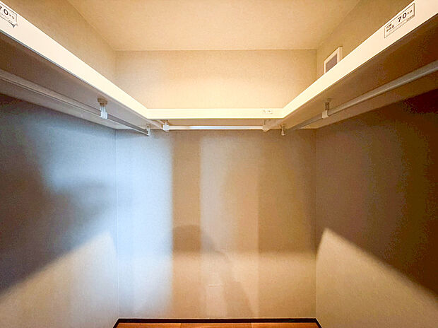 【ウォークインクローゼット】大容量のウォークインクローゼットは、季節物の衣類から大型のスーツケースまで効率よく収納できる機能的な設計です。枕棚とハンガーパイプをコの字型に配置することで一目で持ち物が把握できスムーズに愉しめます。