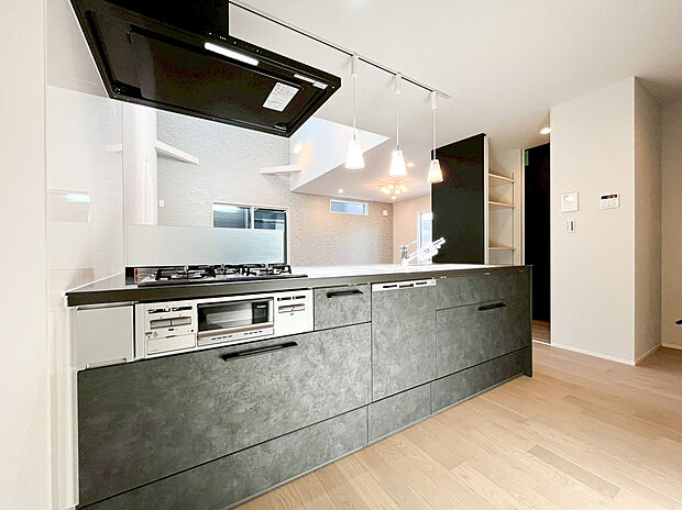 【キッチン】モダンなキッチンと、背面収納を同色で統一。奥の吹き抜けと大窓から光が満ちる、開放感あふれる大空間です。家族との会話が弾む、理想のキッチンライフを叶えます。