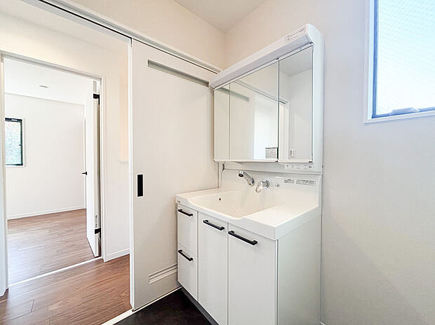 【洗面化粧台】たっぷりの大型収納を設けたシャワー付き洗面台で快適な暮らしを。収納力と機能性に優れたお手入れラクラクのゆったりとした洗面台で、朝の忙しい時間でも身支度準備がスムーズに出来そうですね。