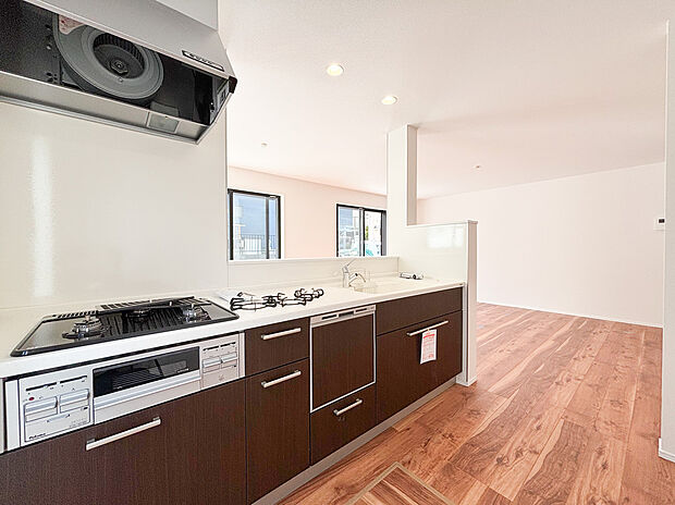 【システムキッチン】料理中も家族との会話が弾む、開放的な対面式システムキッチンです 。落ち着いたダークブラウンのデザインが、LDKに洗練された印象を与えます 。