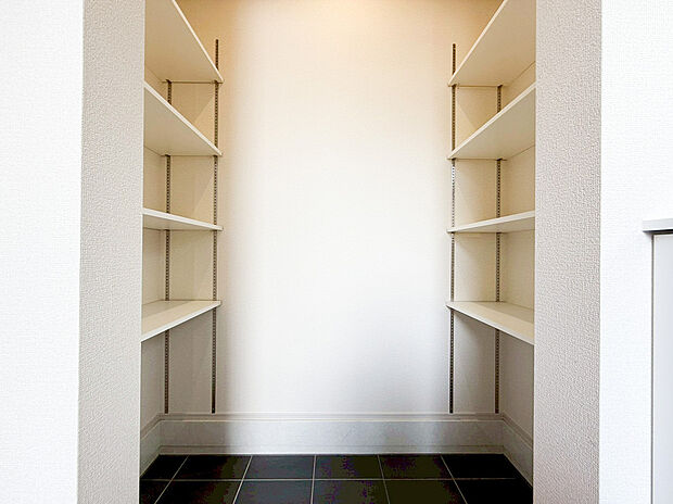 【大容量シューズインクローゼット】玄関横に配置された、ベビーカーやゴルフバッグもそのまま収納できる便利な土間収納です 。左右に備え付けられた棚は可動式で、靴の高さや荷物の大きさに合わせて自由にレイアウトが可能。