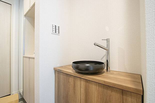 【玄関すぐの洗面台】落ち着いた空間を演出するカラーと、ゆったり落ち着いてお使い頂ける広さが魅力の洗面所。居室からも独立しており、プライベート空間を保ちます。