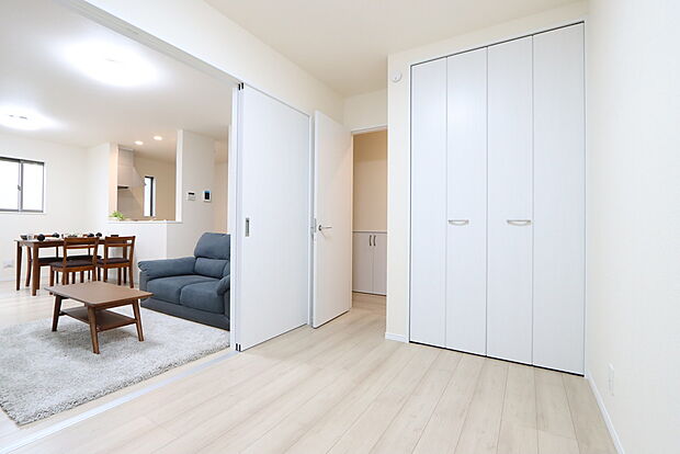 【リビングと一体で使える個室　K号棟】リビングに隣接する個室に段差がない間取ですので、引き戸を開け放てば２部屋が一体となり広々に。快適空間が生まれることで、家族が集まりやすくなります。

