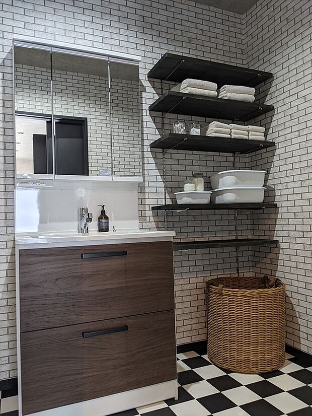 【見せる収納の洗面空間参考画像（インダストリアルハウス）】レンガ調クロスとブラックの棚が印象的な洗面空間。見せる収納で機能性とデザイン性を両立し、日常使いも楽しくなるインダストリアルな仕上がりです。
