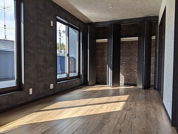 【大容量収納付き洋室参考画像（インダストリアルハウス）】大容量のクローゼットを備えた洋室空間。衣類や季節物もしっかり収納でき、お部屋をすっきりと保てます。ダークトーンの壁と木目の床が印象的で、インテリア次第でさまざまな雰囲気を楽しめるのも魅力。寝室や子ども部屋、ワークスペースなど幅広く活用可能です。収納力とデザイン性を兼ね備えた、使い勝手の良い空間です。