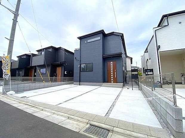 【現地外観写真】5号棟　モダンで洗練された外観デザイン。木目調の玄関ドアが温かみを添え、スタイリッシュな中にも落ち着きのある表情を作り出しています。周囲の街並みと調和しつつも個性が光る、こだわりの一邸です。