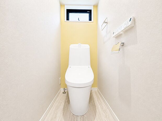 【トイレ】清潔感あふれる明るいトイレ空間。背面のアクセントクロスがさりげない彩りを添え、シンプルながら心地よい雰囲気に仕上がっています。