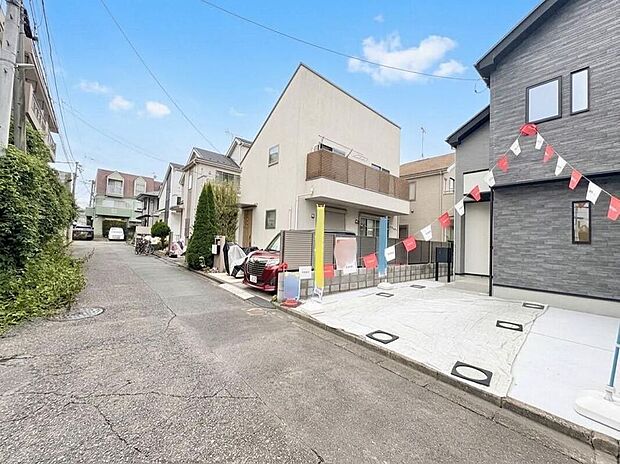 【現地外観写真】青空の下、モダンな外観が目を引く住まいです。穏やかな街並みは、お子様とのびのびと暮らせる理想の環境を提供します。