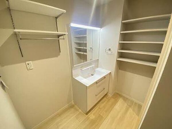 画像3:洗面化粧台と収納棚の付いた洗面所空間です。