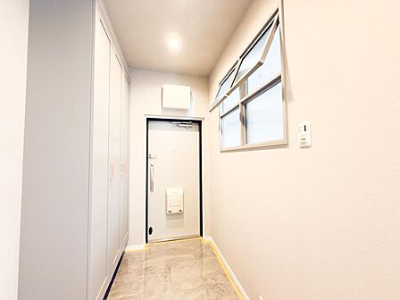 明るく清潔感のある玄関スペース。隣の部屋と繋がった窓がオシャレです。